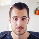 Person with slicked-back hairstyle indoors.